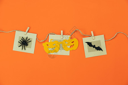 万圣节到了手工制作的欢乐万圣节日背景假期概念Flat为派对南瓜的摄影道具和挂在橙色壁纸剪贴上的蜘蛛蝙蝠设定了物体这些天恐怖躺着插画