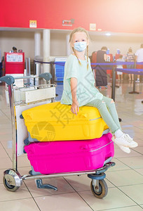 假期小可爱的带着外科面具的小孩在国际机场面对保护在机场等待登的小孩在场等待登飞白种人背景图片