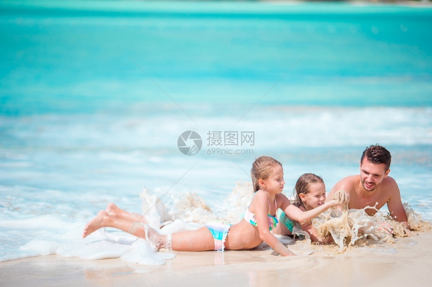 女父亲和孩子们享受海滩暑假父亲和小孩享受海滩夏天的假期在浅水中玩耍享受海滩夏季热带度假溅起绿松石图片