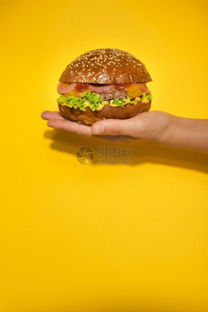 质量手握经典牛肉汉堡和生菜高分辨照片手持经典牛肉汉堡和生菜优质照片美不良小吃图片