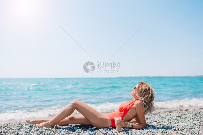 在沙滩上享受假期的女士图片