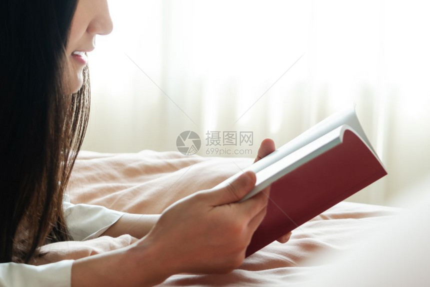 躺着潮人袜子世界书日女人躺在床上阅读空白书本图片