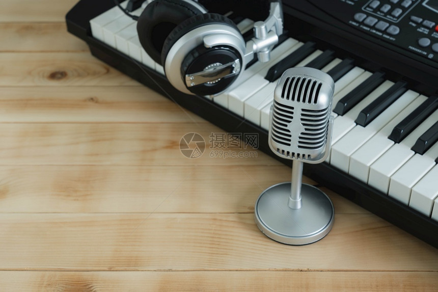 笔记玩关闭一组音乐工具包括用于创意设计文字的棕色木制复空间上的银式耳机电子键盘等用于创造设计文字的新型木制模拟空间乐队图片