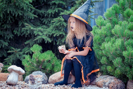 年轻的出没收成秋天万圣节时穿着巫服的小女孩肖像Trick或者用杰克南瓜特里或治疗来给快乐女孩看图片