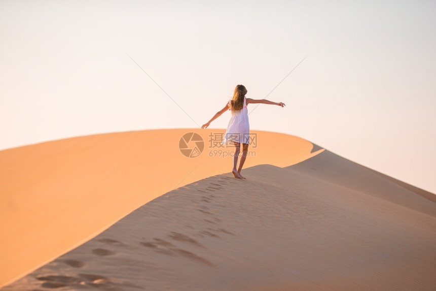 自然风景优美小女孩在阿拉伯联合酋长国沙漠的丘中享受假期阿拉伯联合酋长国RubalKhali沙漠丘中的女孩图片