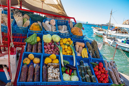 甜的希腊Aegina岛港口一艘船上的市场摊位蔬菜南瓜柠檬图片