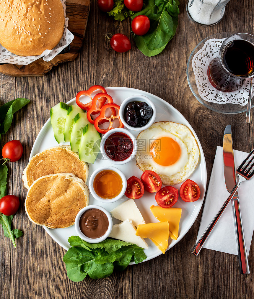 巨大的健康早餐散布在桌子上咖啡茶番茄鸡蛋煎饼果酱和奶酪奏鸣曲食物浆果图片