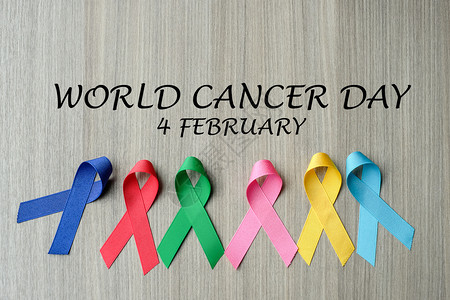 世家癌症日二月24日世界癌症2月4以木制背景为蓝红绿粉色和黄颜的彩带支持人们生活和疾病保健医药概念蓝色的绿背景