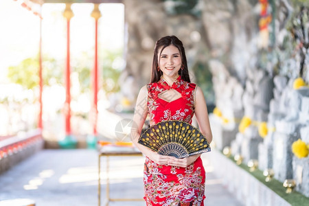 时尚风向毛笔字时尚可爱的美丽亚洲年轻女子身着传统红青山装饰在泰国华神庙举办中新年节盛会的风向节日活动校对Portnoy背景