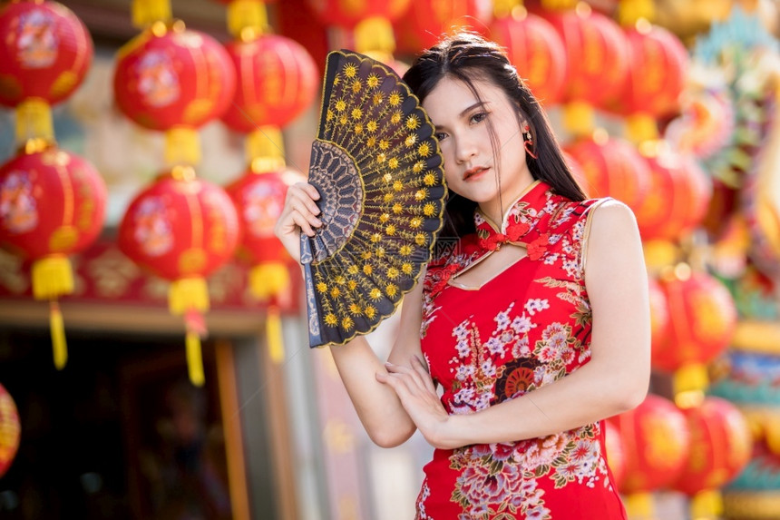 年轻的亚洲女子身着传统红青山装饰在泰国华神庙举办中新年节盛会的风向节日活动校对Portnoy保持抽象的图片