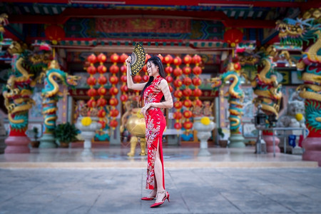 时尚风向毛笔字亚洲年轻女子身着传统红青山装饰在泰国华神庙举办中新年节盛会的风向节日活动校对Portnoy年轻的服装衣背景