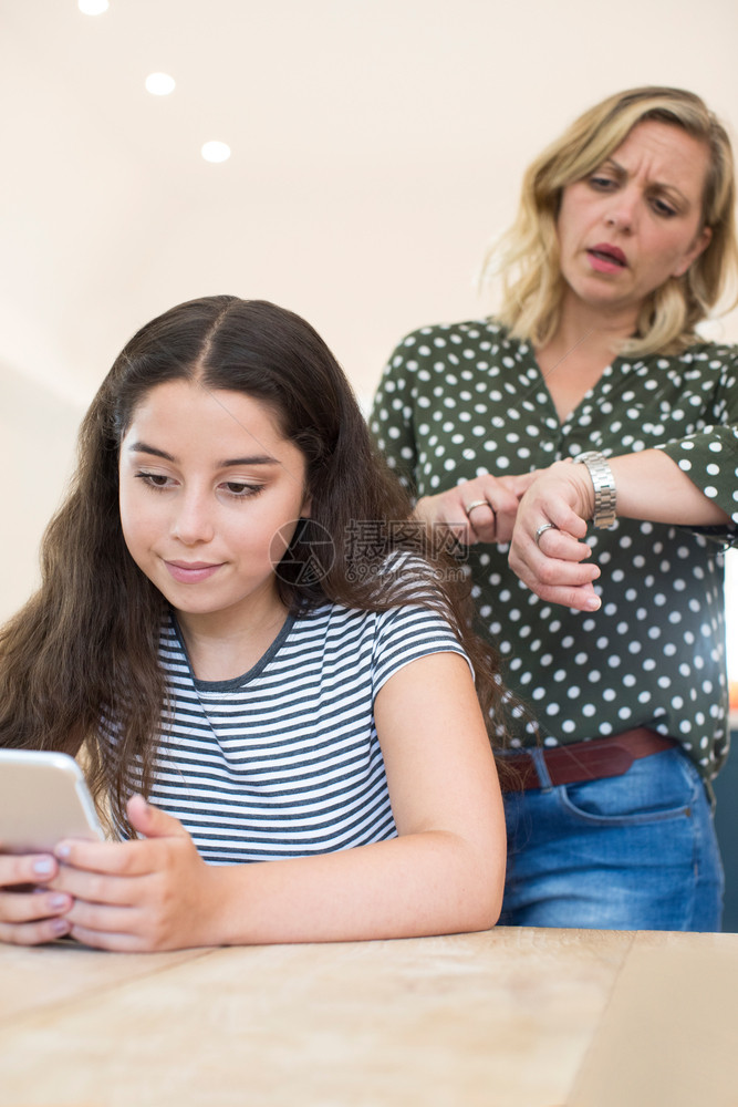 连接的叉发短信母亲与使用移动电话的少女儿争论过量使用移动电话图片