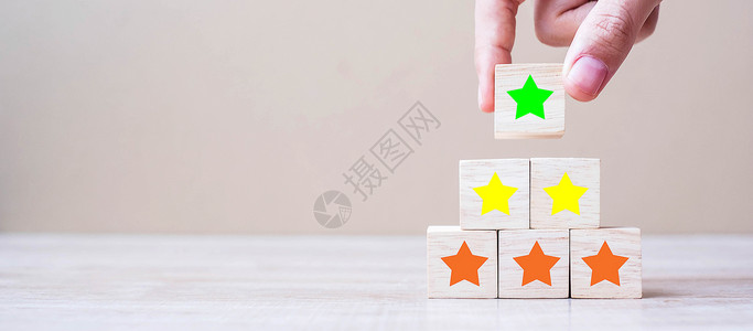 拿着木块的手评估顾客拿着带有星号的木块顾客评论反馈级排名和服务理念横幅产品设计图片