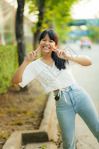 女士身着轻松便衣的亚裔青少年可爱的脸容站在市街旁边衣服皮肤图片
