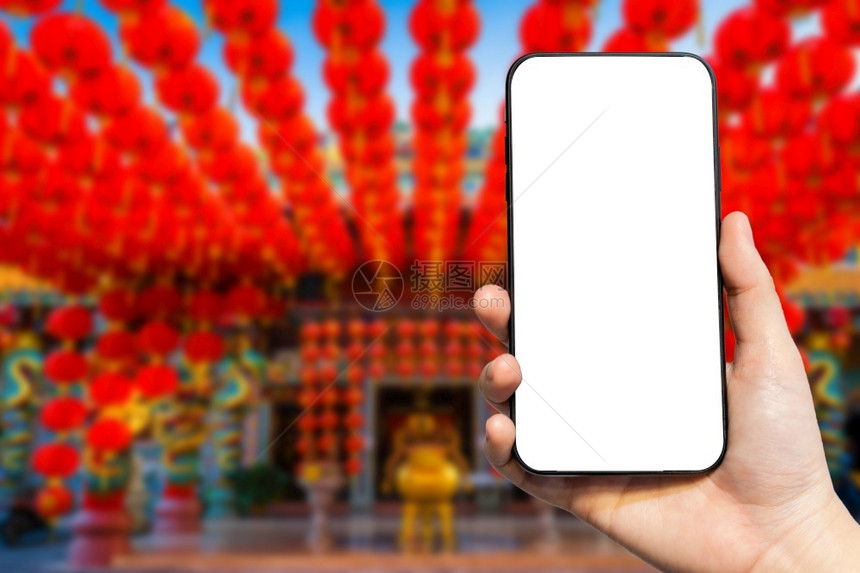 新的在神庙新年庆典美华红灯装饰中女使用智能手机的近身图像模糊化插灯笼应用程序图片