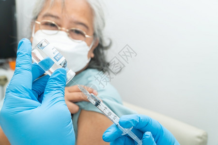 医生戴口罩为老年病人接种疫苗图片