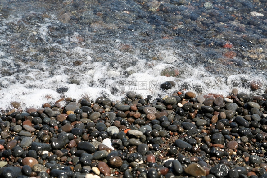 水浪漫的闲暇希腊圣托里尼岛的卡马海滩带有黑色火山石图片