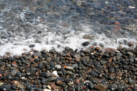 水浪漫的闲暇希腊圣托里尼岛的卡马海滩带有黑色火山石图片