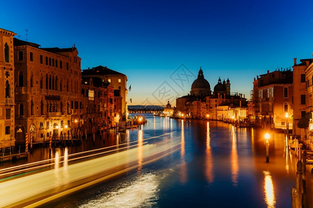 历史威尼斯的圣玛丽亚德拉萨鲁特在格兰德运河夜射中建筑学贡多拉背景图片