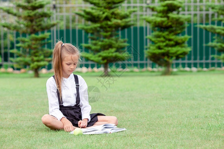 在草地上读书的小学生图片