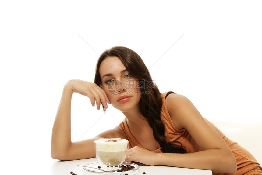 美丽的女人在桌子上弯曲卡布奇诺在白背景的桌子上弯曲卡布奇诺坐着漂亮的牛奶图片