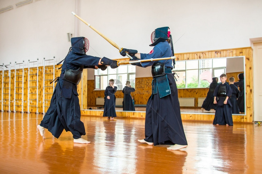 吸引人的与Kendo刀学校斗争培训男子和儿童与Kendo学校战斗工作室白种人图片