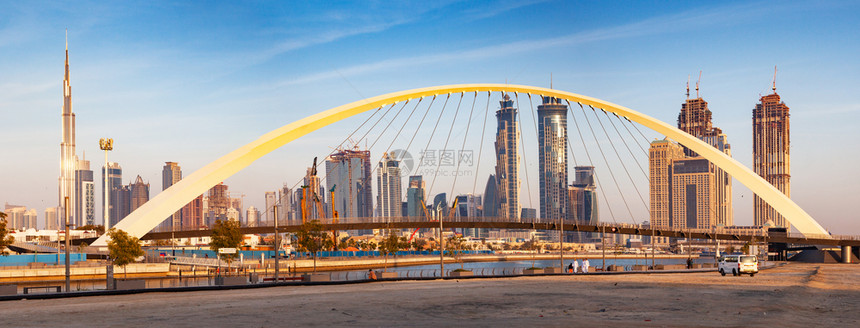 看过迪拜市中心摩天大楼和新建的容忍桥上从迪拜水渠中可以看出日落是多彩的地标黎明图片