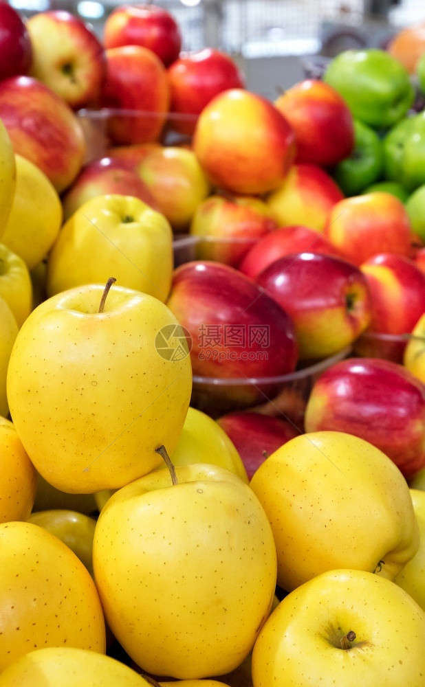 金色的明亮黄苹果以及模糊的红苹果和绿躺在柜台上集市垂直图像缝合复制空间售出黄色红绿苹果在市场上出售背景模糊纵向图像被卖出形式一种图片