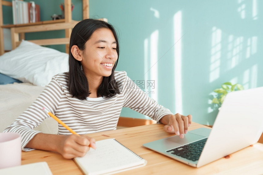 坐着亚裔孩童在家中做晨间庭内务时学习在家网上概念YTFyorKlearingofcomnetleaking一种在家上学图片