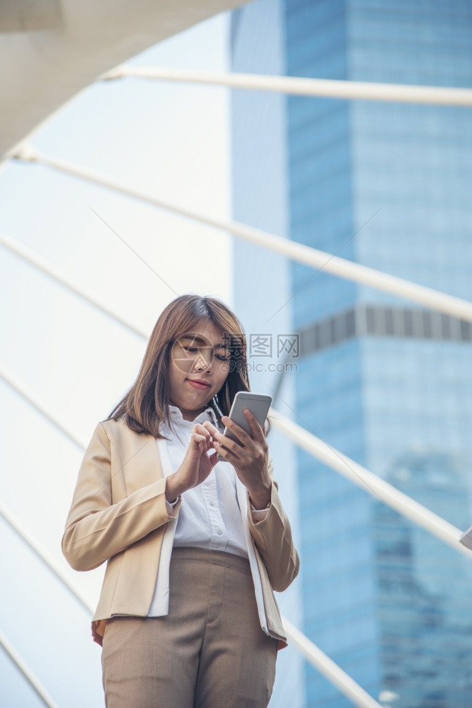 使用智能手机在线购物打电话发短信互联网技术生活方式的女商人使用手机在城市街道上行走智能手机自信女现代城市聊天首席执行官图片