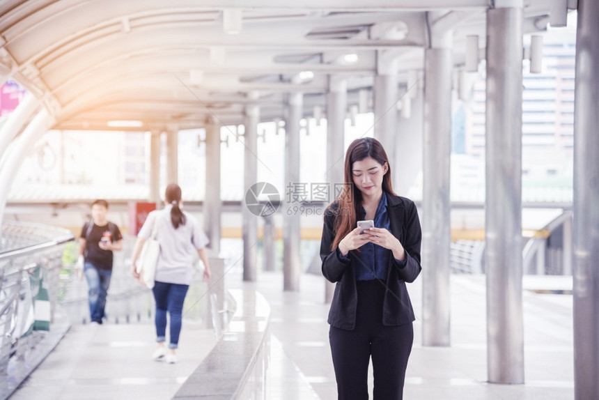 办公室现代的使用智能手机在线购物打电话发短信互联网技术生活方式的女商人使用手机在城市街道上行走智能手机自信女现代城市聪明的图片