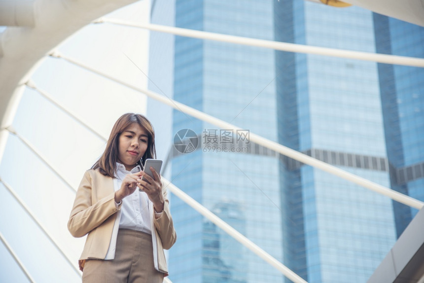 女士使用智能手机在线购物打电话发短信互联网技术生活方式的女商人使用手机在城市街道上行走智能手机自信女现代城市天信息图片