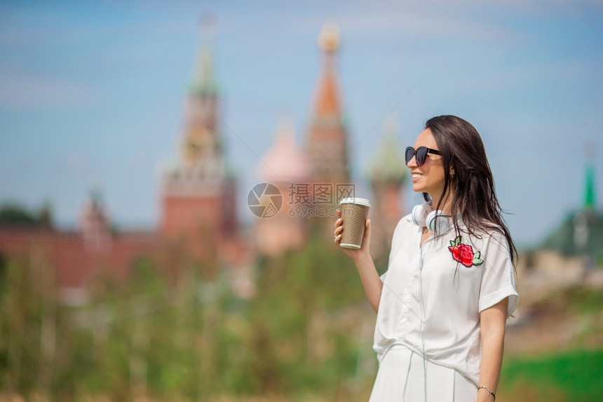 正方形快乐的城市年轻女喝咖啡户外圣巴西尔斯教堂背景快乐的城市年轻女喝咖啡在欧洲城市探险家场景图片