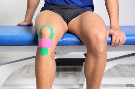 H5动效粘合剂嬉戏的程序年轻运动型男员用型胶带治疗受伤的膝盖特写运动学物理疗法康复概念背景