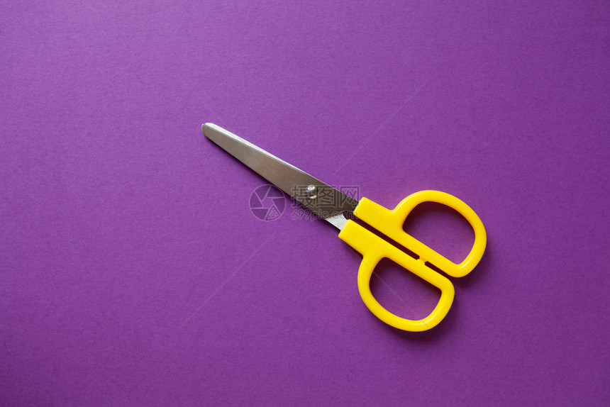 黄色儿童文具右手剪刀紫纸背景面回学校DIY概念上观复制空间倾斜紫色的工具图片