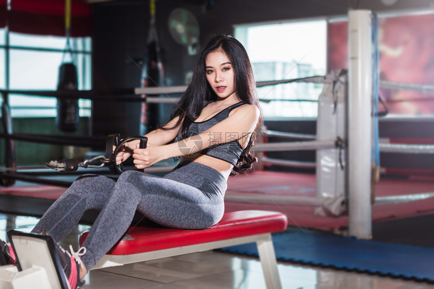 表演锻炼活动亚洲女在体育健身室内和康俱乐部中以运动设备Gym背景体操训练用划线机座位有电缆机器进行锻练训的亚裔妇女图片