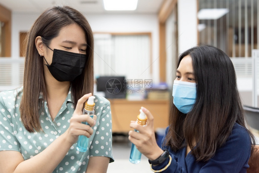 戴口罩的女性手拿消毒酒精图片