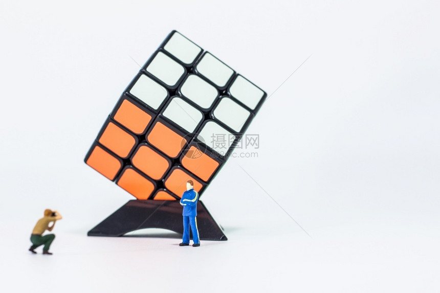 解决了男摄影师拍了魔方赢家3x的立方体在白色背景上的照片服用游戏图片
