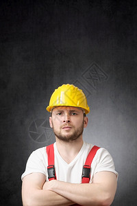 职业难的帽子愤怒建筑工人用他手横穿了肮脏的建筑工人用他的手臂跨过图片