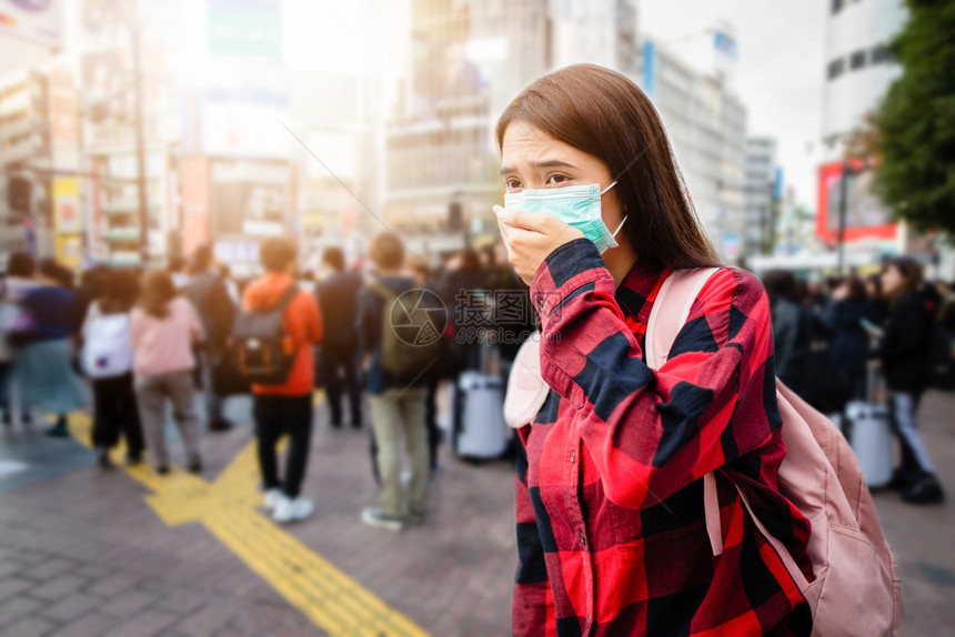 城市里戴口罩预防感染的女性图片