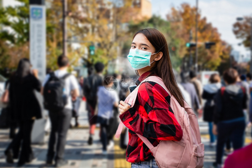 户外戴口罩预防感染的女性图片