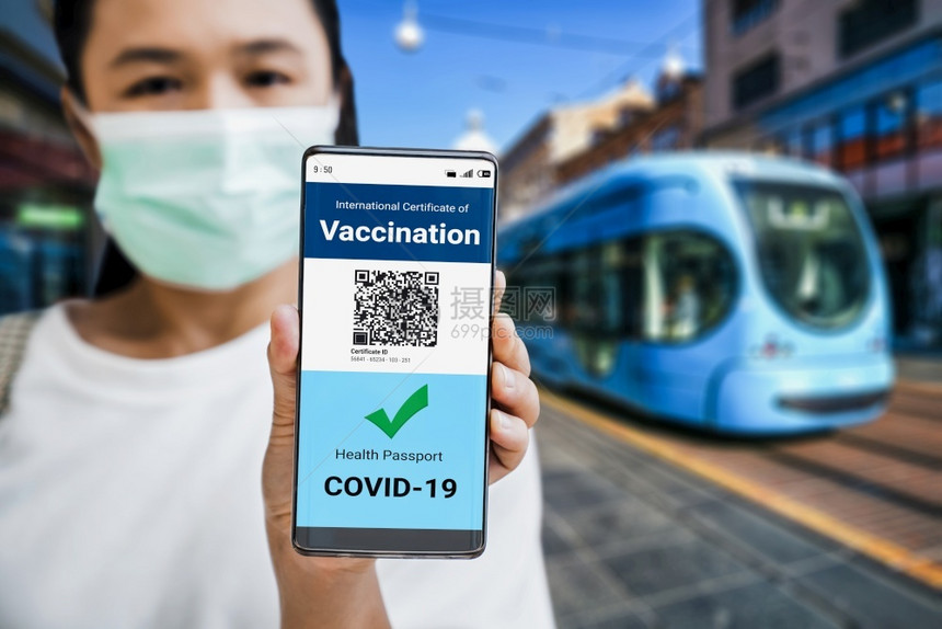 旅行者持有疫苗护照证书以显示COVID19疫苗接种状态在冠大流行期间国际旅需要数字健康证书疫苗接种状态oopicapi面具城市的图片