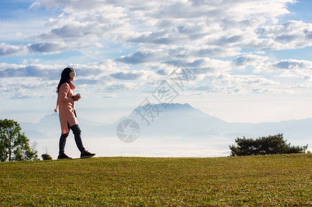 一位年轻女子看着山和雾海图片