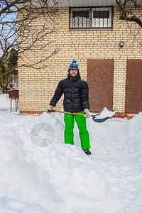 大雪后铲雪的男人图片