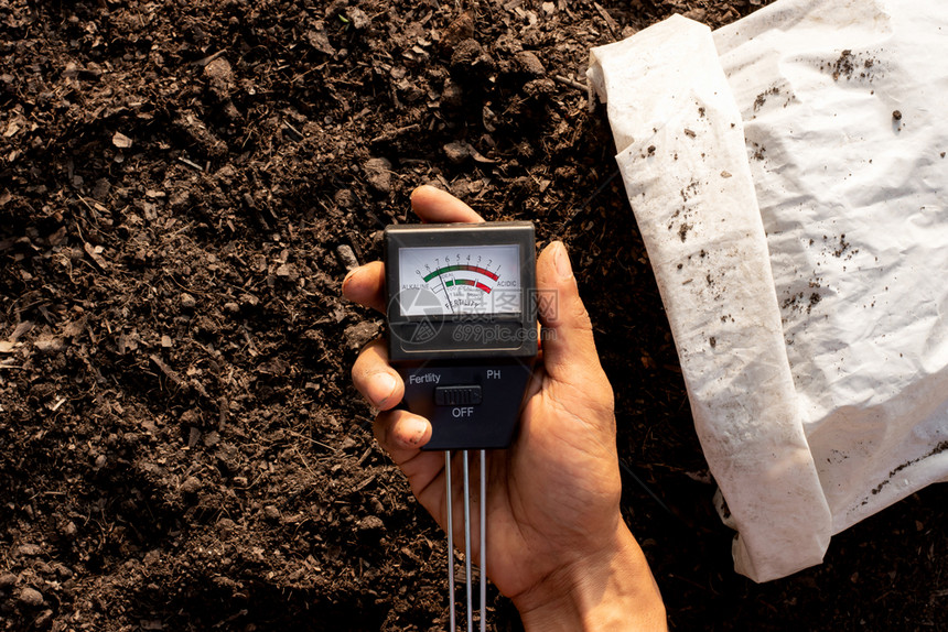 环境的土壤质量测表落在正检查土壤以植种的男子手中一图片