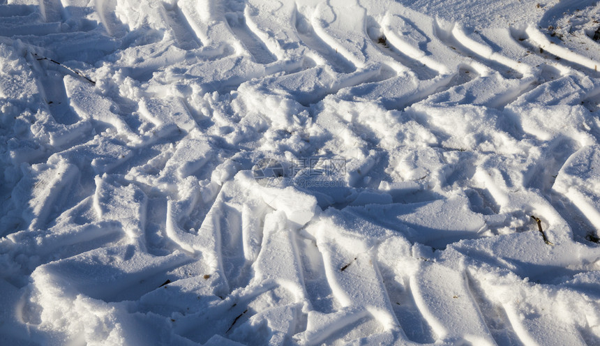 自然痕迹旅行白雪上留下的车胎足迹照片以一个角度拍摄的近距离小深田地雪上汽车的踪迹图片