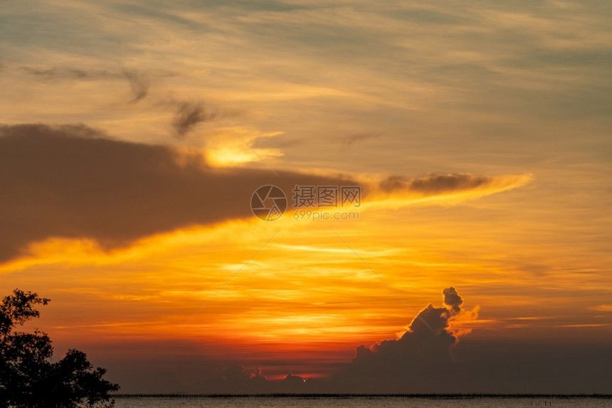 热带海中美丽的日落天空热带海的金色夕阳天边的际自然中美人热带海滩观光日落天空的景色上红和橙云层假期放松海岸图片