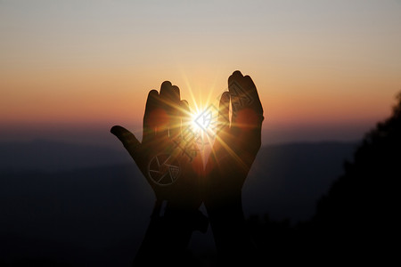 爱闪耀信仰的圣洁祷告将阳光照耀在模糊的美丽日落背景下图片
