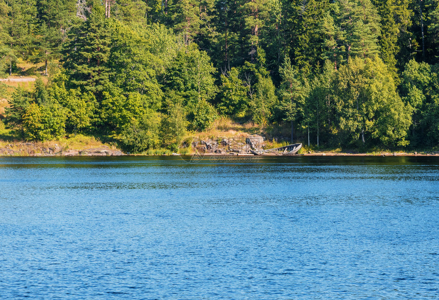 天旅游悬崖森林湖有一艘古老的夏季船被一艘旧扔在岸上图片