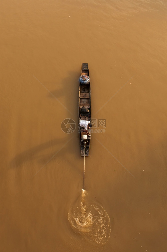 农业乡村的血管在泰国日出农村景点在一条河流上投渔网时站在传统木制渔船上悬挂着亚洲渔民的空中观视线关注渔民图片
